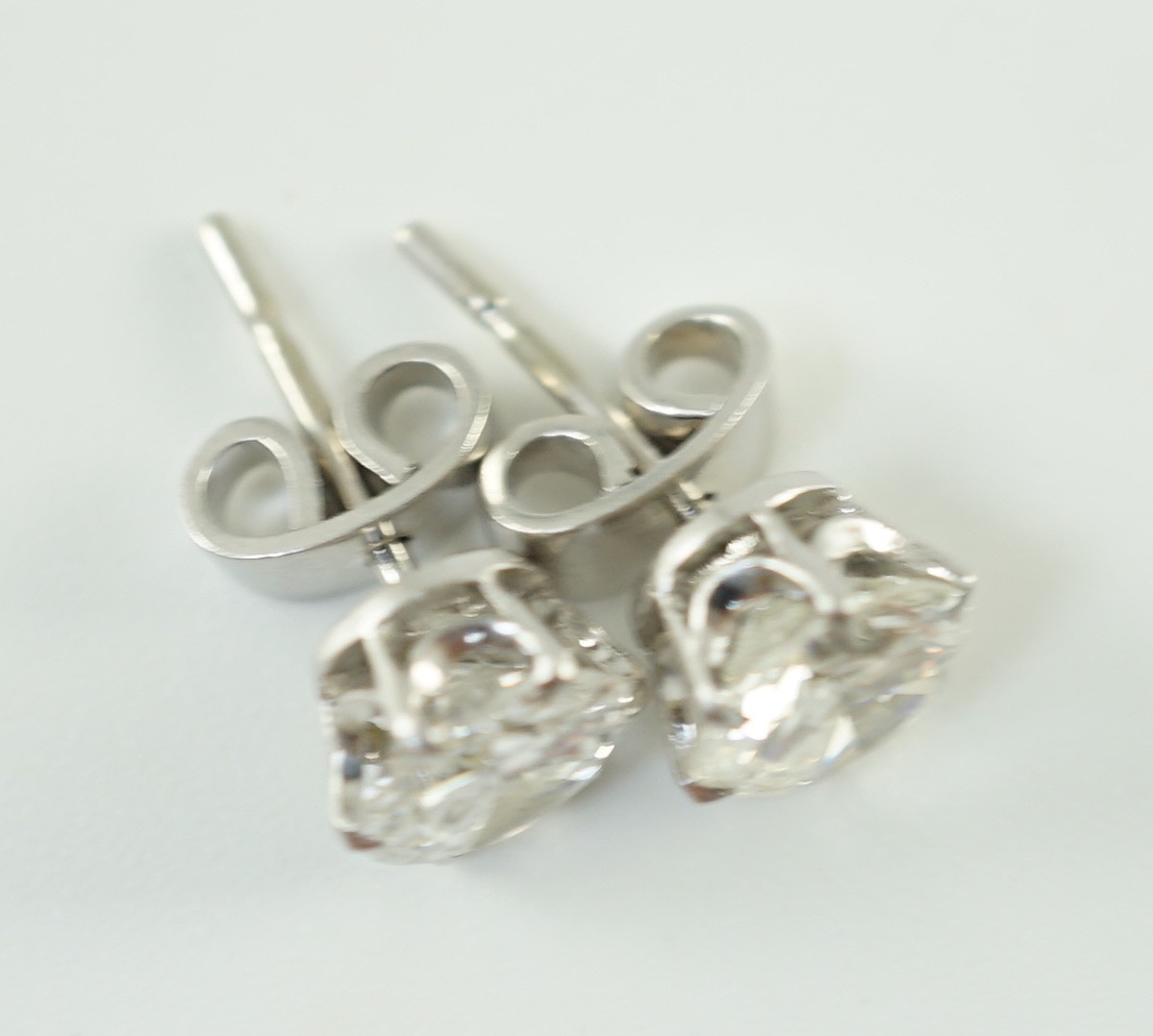 A pair of white gold and solitaire diamond set ear studs